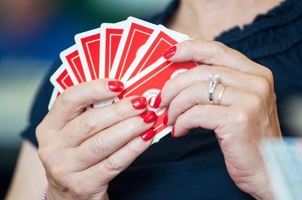 	<p>A player looks at her hand of cards, June 30, 2013, at Demonstration Hall during a bridge tournament. The event was hosted by the American Contract Bridge League. Justin Wan/The State News</p>