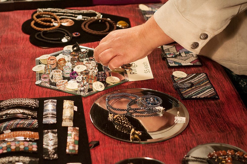	<p>Grand Ledge resident Cathy Carelli looks at some of the handmade jewelry at the 28th annual Women in the Arts Festival. The event was held at Edgewood United Church as a showcase for art including sculpture, jewelry, music and poetry.</p>