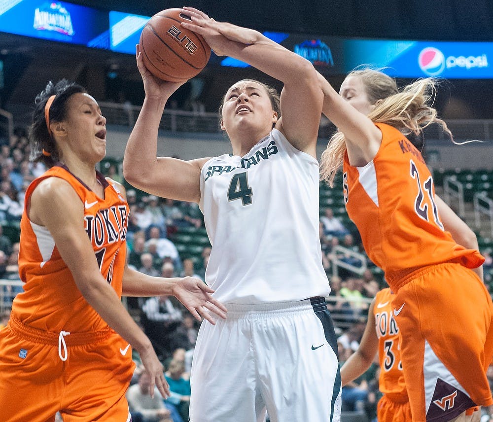 	<p>Sophomore center Jasmine Hines tries her hand by the baseline while Virginia Tech guard Lauren Evans, left, and forward Alex Kiss-Rusk try to stop the play. The Spartans defeated the Hokies, 57-29, Nov. 18, 2012, at Breslin Center. Justin Wan/The State News</p>