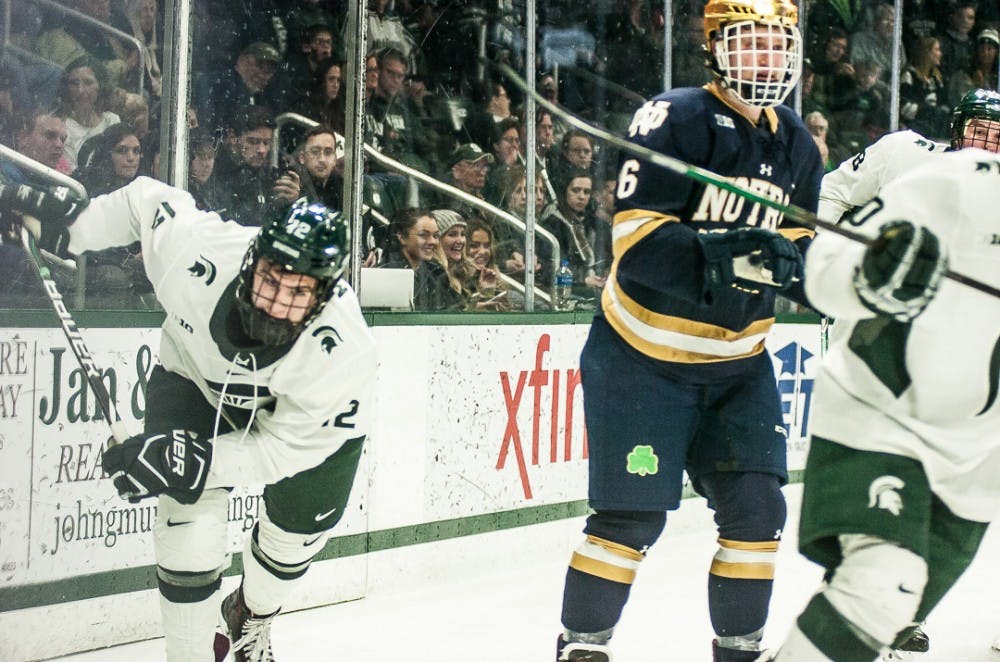 Freshman defenseman Tommy Miller (12) passes the puck during the game on Dec. 1, 2017 at Munn Ice Arena. The Spartans fell to the Fighting Irish 3-1. 