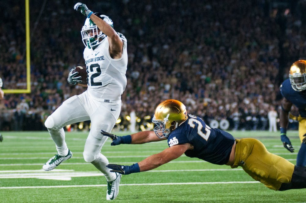 Senior wide receiver R.J. Shelton (12) runs the ball down the field for a touchdown while evading Notre Dame safety Drue Tranquill (23) during the game against Notre Dame on Sept. 17, 2016 at Notre Dame Stadium in South Bend, Ind. The Spartans defeated the Fighting Irish, 36-28.
