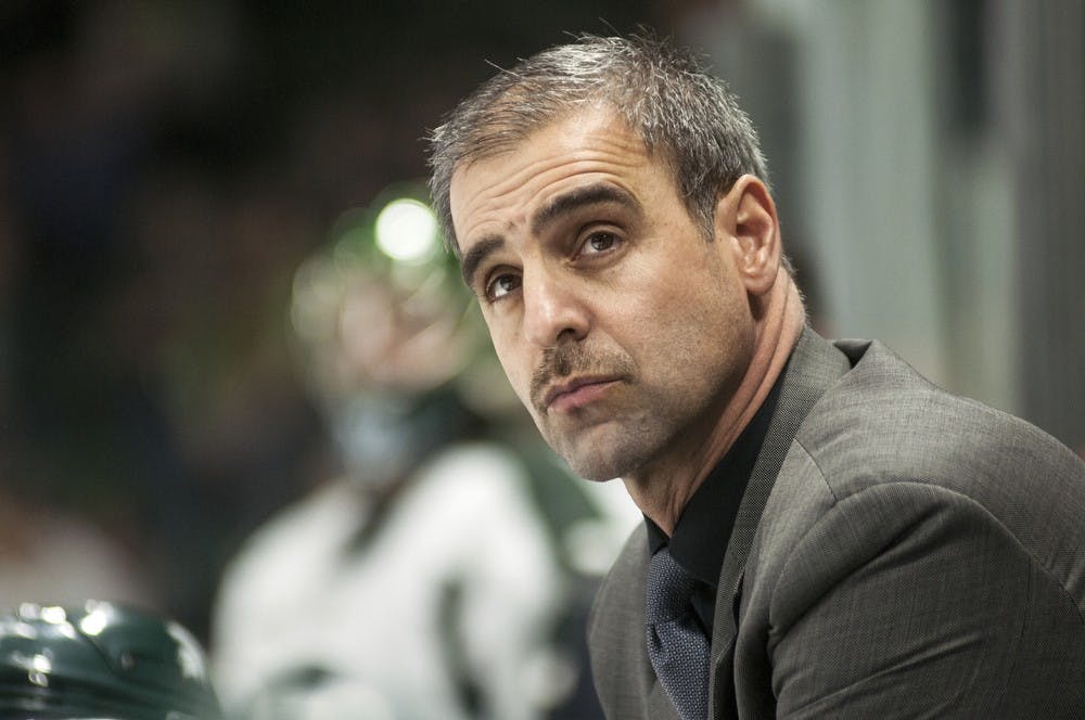<p>Head coach Tom Anastos looks up at the scoreboard during the game against Wisconsin onMarch 14, 2014, at Munn Ice Arena. In overtime the Spartans defeated the Badgers, 5-4. Danyelle Morrow/The State News</p>
