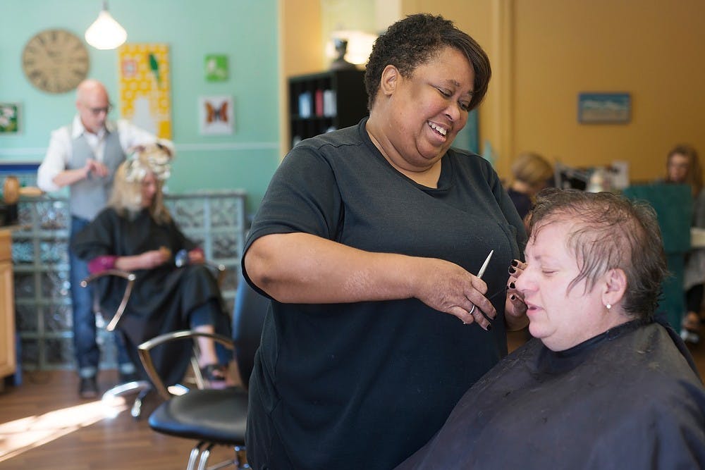 	<p>Hair stylist Vanessa Dungey jokes with Williamston, Mich., resident Rosaria Hoeffner on Sept. 5, 2013 at Applause Salon, 1447 E. Michigan Ave. in Lansing. Dungey has cut Hoeffner&#8217;s hair for more than 21 years. Julia Nagy/The State News </p>