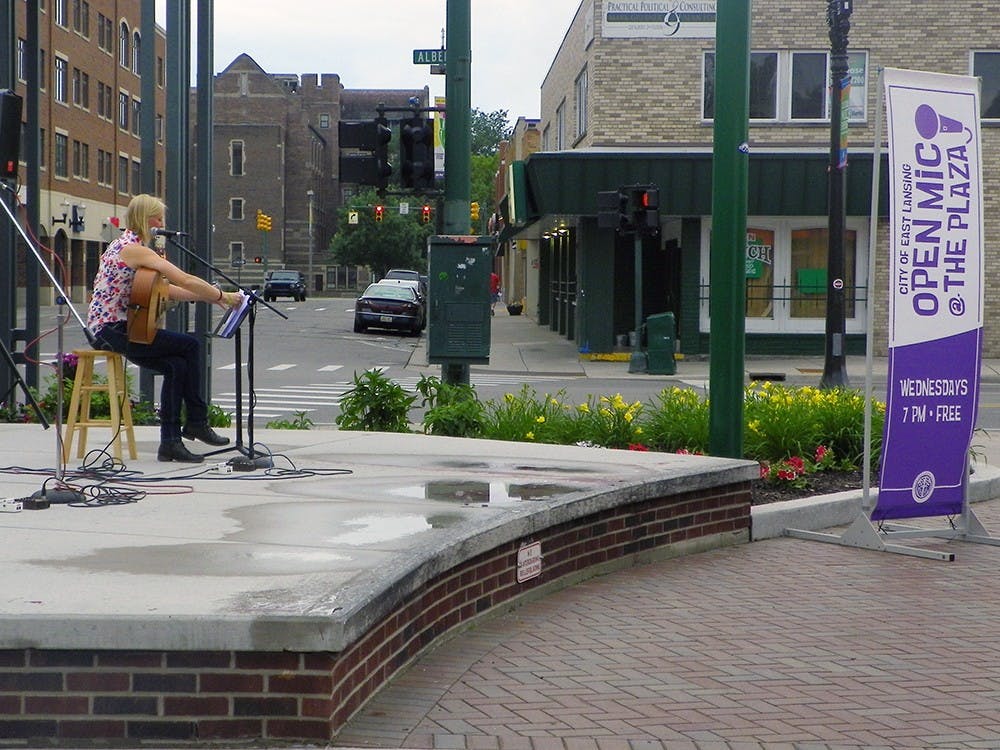 <p>MSU athletic trainer Salina Halliday plays a rendition of "Seven Nation Army" by The White Stripes June 17, 2015, for Wednesday's open mic night at the Ann Street Plaza in East Lansing. Ryan Kryska/The State News</p>