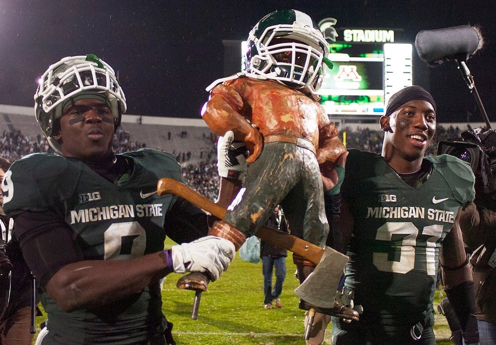 	<p>Senior safety Isaiah Lewis and senior cornerback Darqueze Dennard hold the Paul Bunyan trophy after a game against Michigan on Nov. 2, 2013, at Spartan Stadium. The Spartans defeated the Wolverines, 29-6. Georgina De Moya/The State News</p>