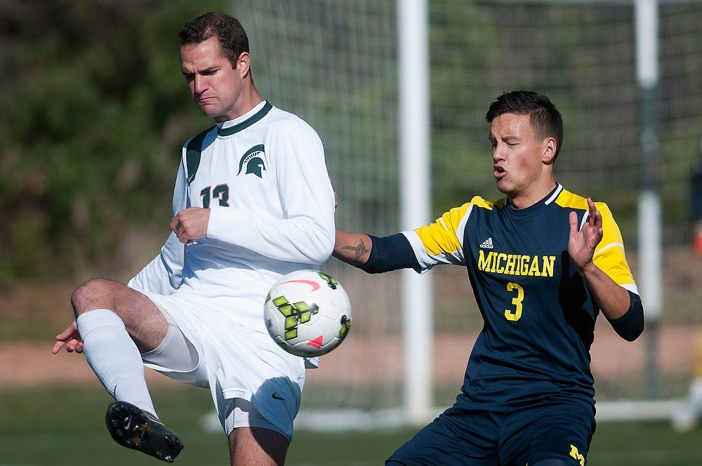 <p>Then-senior forward Adam Montague kicks the ball away from Michigan defender Andre Morris on Nov. 2, 2014, at DeMartin Stadium at Old College Field. The Spartans lost, 3-2. Julia Nagy/The State News</p>