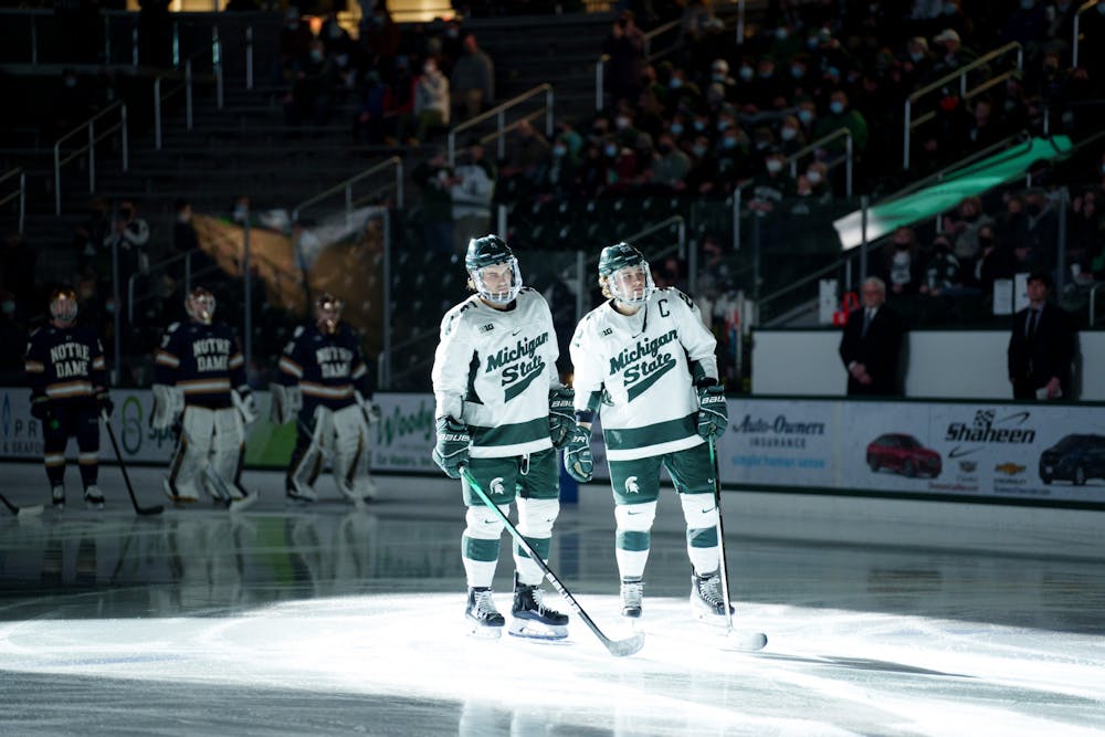 <p>Michigan State hockey players sophomore Kristof Papp and senior Dennis Cesana during introductions before their game against Notre Dame on Feb. 18, 2022. Spartans lost 2-1 against Notre Dame. </p>