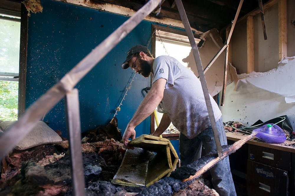 	<p>Gabe Purdy, an employee for the Student Housing Cooperative, helps clean a room damaged by an early morning fire at Phoenix cooperative, 239 Oakhill Ave, on Sept. 4, 2013. Responders got a call at 3:02 a.m. about a fire that started on the second floor of the building. Julia Nagy/The State News</p>