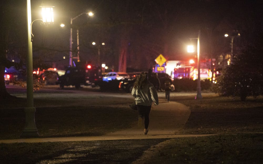 A student runs home after being released from the shelter-in-place during the mass shooting on Monday, Feb. 13, 2023 Michigan State University’s North Neighborhood.