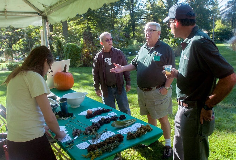 	<p>Lansing resident Dave Veale, left, volunteer coordinator Ron Overton, center, and botanical technician Pete Murray, right, gather around to look at the naturally dyed strings. The event included cider and doughnuts, a pumpkin giveaway and presentations about the history of Beal Garden. Brian Palmer/ The State News</p>