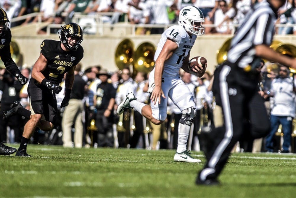 <p>Redshirt sophomore quarterback Brian Lewerke (14) runs for a touchdown during the first quarter of the football game against Western Michigan on Sept. 9, 2017 at Spartan Stadium. The Spartans defeated the Broncos, 28-14.</p>