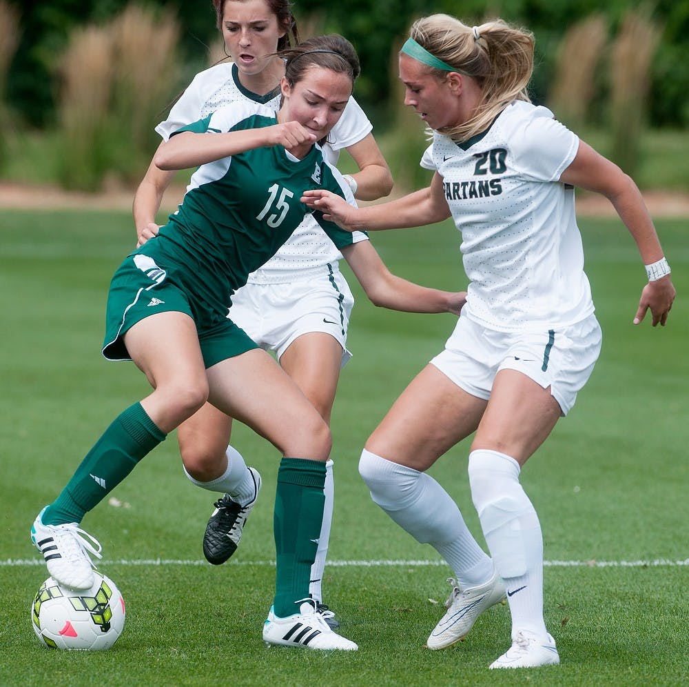 <p>Junior midfielder Kirsten Evans and Eastern Michigan defender Chanel Vani fight for possession of the ball on Aug. 29, 2014, at DeMartin Stadium at Old College Field. The Spartans defeated the Eagles, 3-0. Aerika Williams/The State News</p>