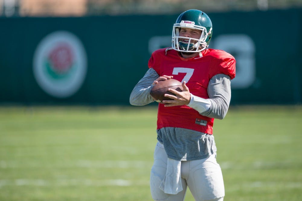 Senior quarterback Tyler O'Connor grasps the football during spring practice on April 5, 2016 at the practice fields behind the Duffy Daugherty Football Building.