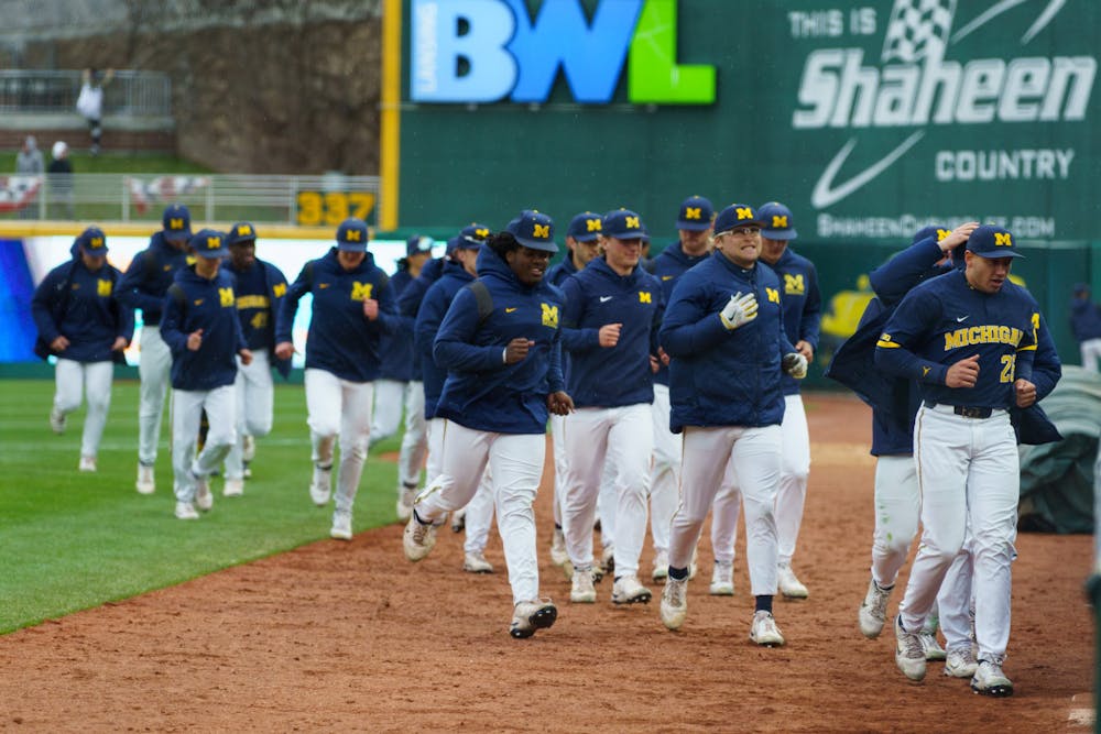 <p>Half of the Michigan team running back in the rain after doing a quick stretch. Michigan State lost 18-6 to Michigan on April 15, 2022 at the Lugnut Stadium.</p>