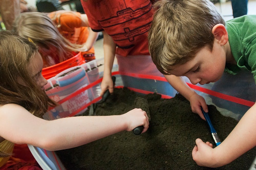 	<p>Lansing residents Nolan Crowley, 3, and Grace Crowley, 6, dig for artifacts in the dirt as part of an activity for the &#8216;Dig the Past&#8217; event on Nov. 16, 2013, at <span class="caps">MSU</span> Museum Auditorium. The event was geared towards children and families to spark interest in archeology. Brian Palmer/The State News</p>