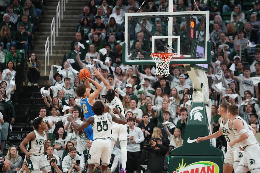 Michigan State junior forward Coen Carr (55) and freshman Jordan Scott (6) play defense against UCLA at the Breslin Center in East Lansing, Michigan, on Tuesday, Feb. 17, 2026.