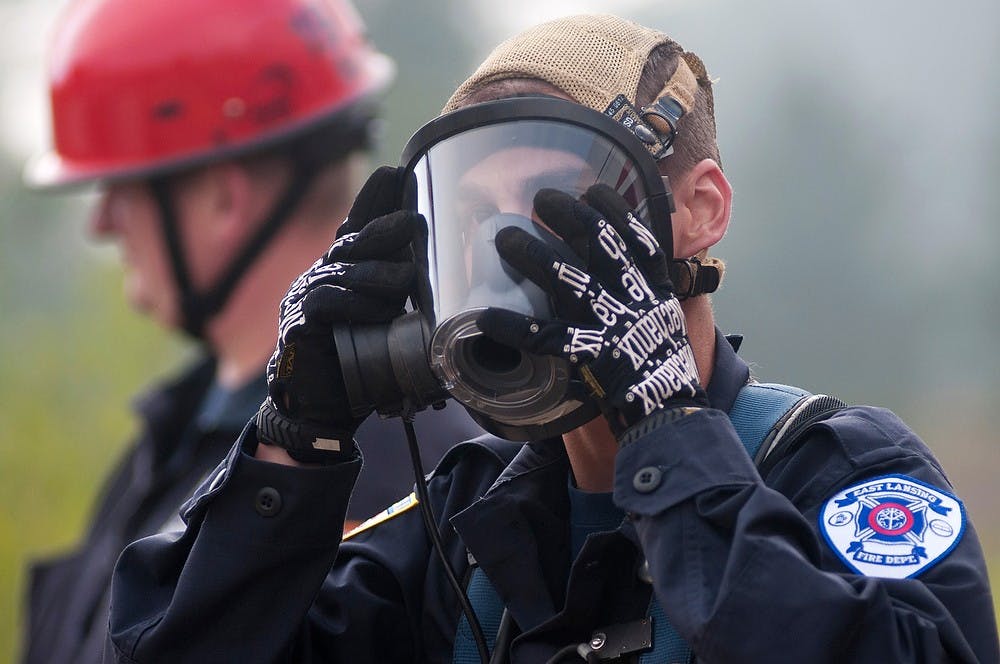 <p>Firefighter Michael Schafer puts on gear before rescue training on Sept. 16, 2014, at Service Road and Farm Lane on MSU campus. Fire departments  from Lansing and surrounding cities are attending training from Sept. 16-18. Aerika Williams/The State News </p>