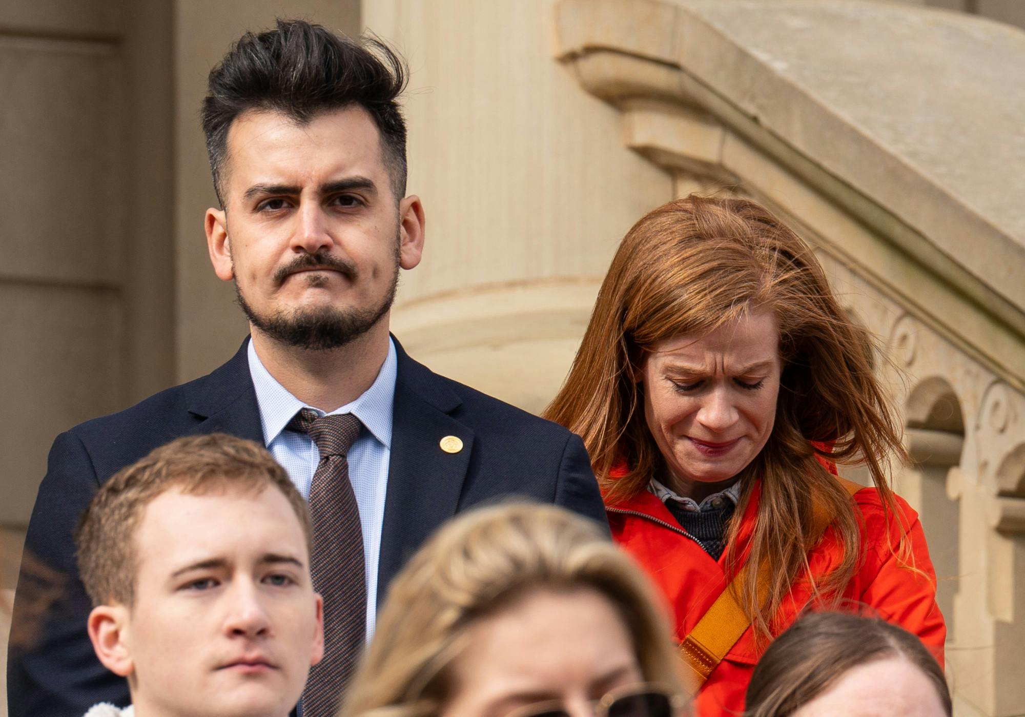 <p>Michigan Senate members Darrin Camilleri and Mallory McMorrow listen on as students speak out against gun violence at the Michigan State Capitol on Feb. 15, 2023. "This should not be a shared American experience," McMorrow said.</p>