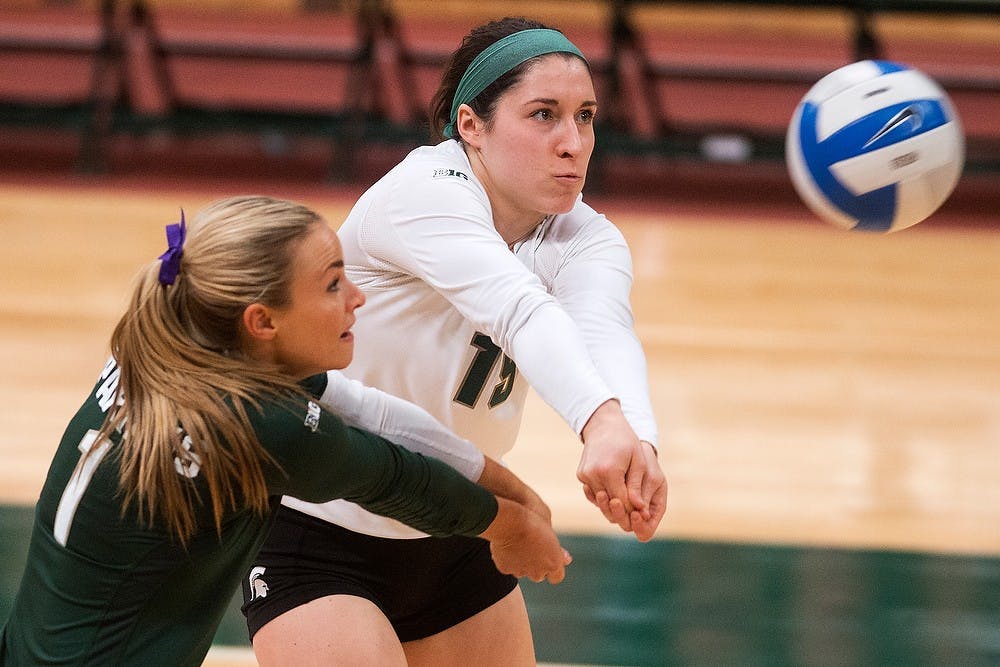 <p>Freshman defensive specialist Marissa Ratzenberger and senior libero Kori Moster go for the ball Oct. 31, 2014, at Jenison Field House during the game against Illinois. The Spartans lost, 3-1. Julia Nagy/The State News</p>