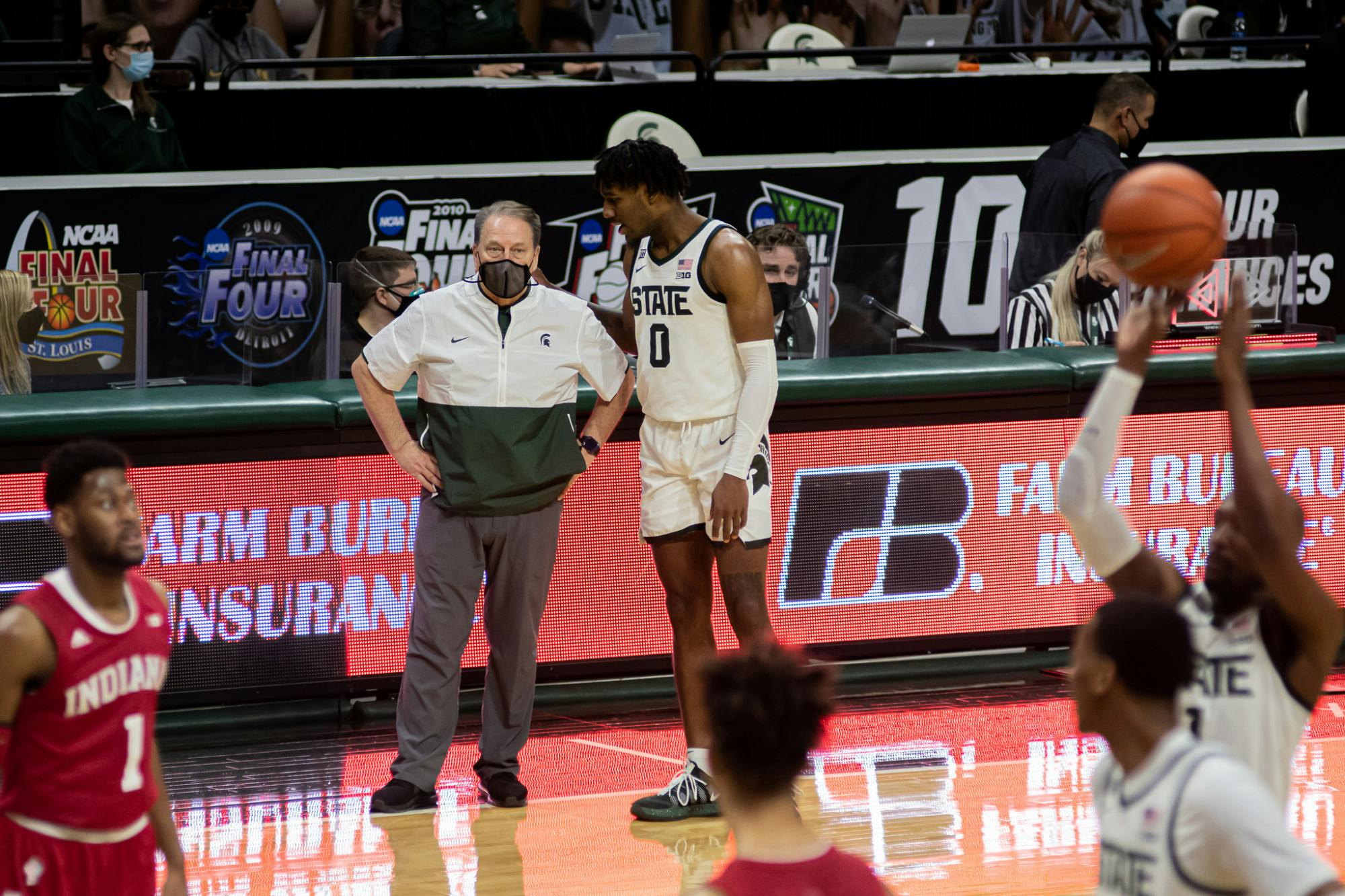Junior forward Aaron Henry talks to Michigan State head coach Tom Izzo as redshirt senior guard Joshua Langford shoots a free throw. The Spartans defeated the Hoosiers 64-58 on Mar. 2, 2021.