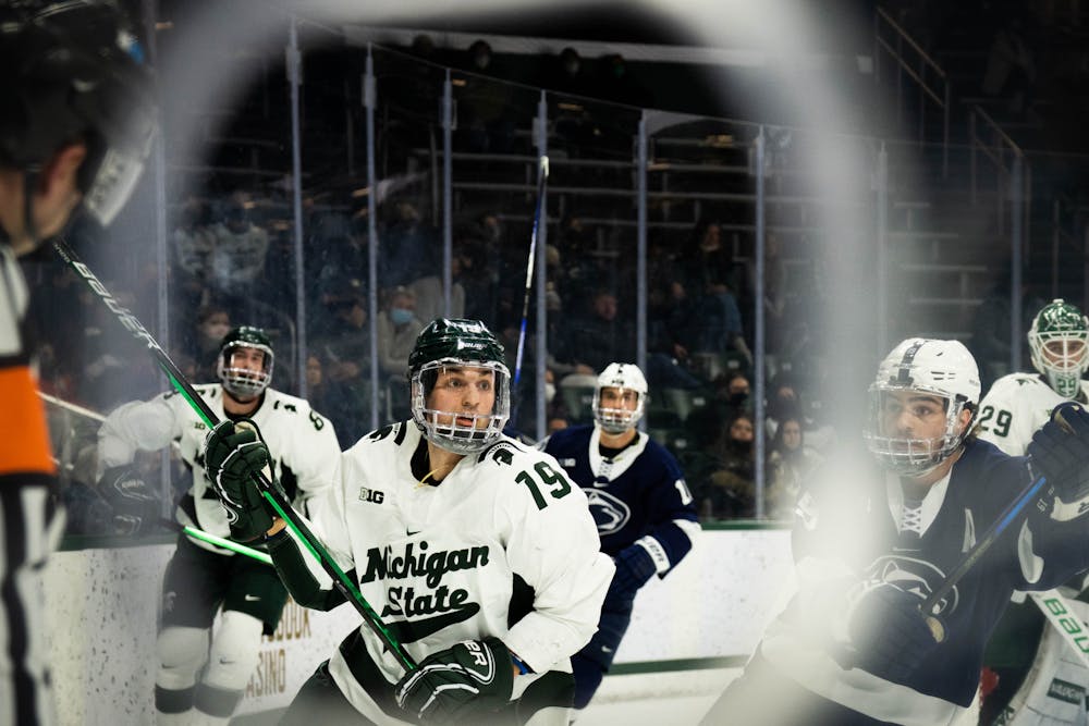 <p>Junior forward Nicolas Müller (19) focuses on the puck during a game against Penn State at Munn Ice Arena on Feb. 25, 2022. The Spartans fell to the Nittany Lions with a score of 5-3. </p>