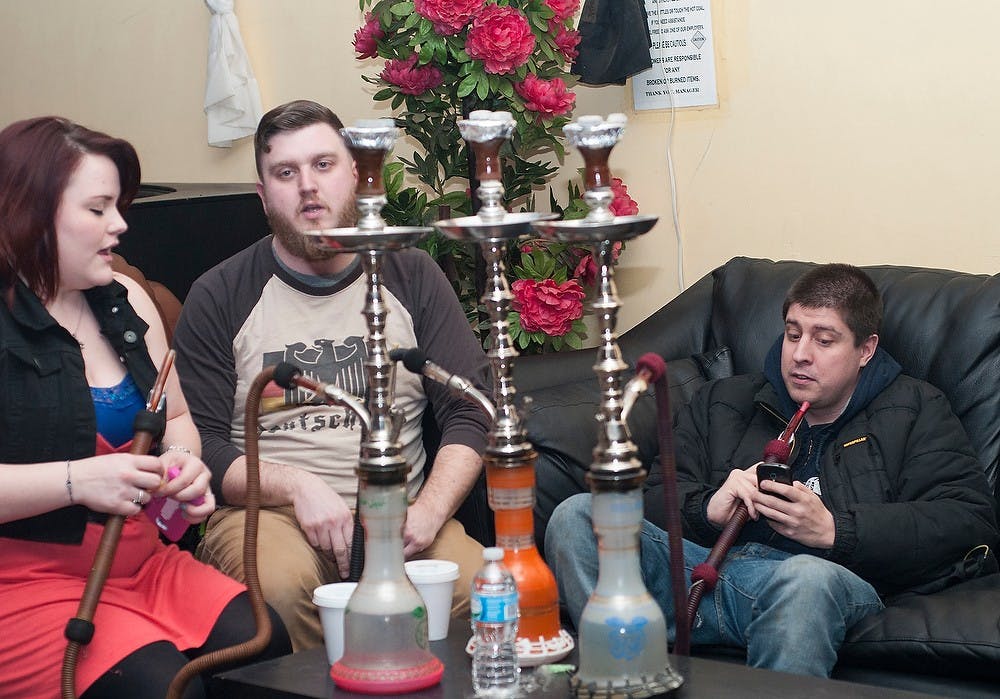 <p>From left, Valerie O'donnell, Ben Coon and Brandon Maupin enjoy company and smoke hookah for global Hookah night Jan. 29, 2015, at Saylis Hookah Lounge & Cafe in Frandor Shopping Center. The event  is hosted by Somali Association of Michigan and the Arab Cultural Society. Hannah Levy/The State News</p>