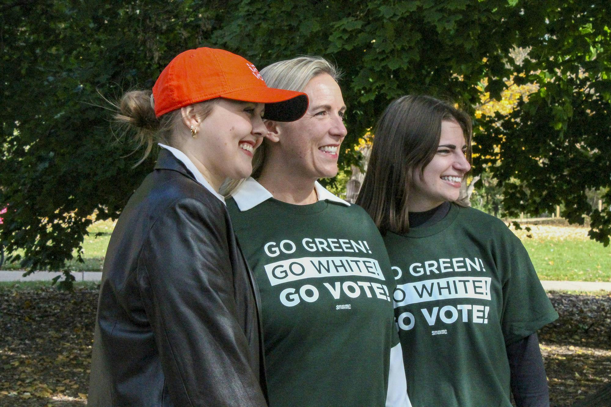 <p>Organizers and attendees pose for a photo with Ingham County Clerk Barb Byrum at an early voting rally outside of People's Park on Oct. 28, 2024.</p>