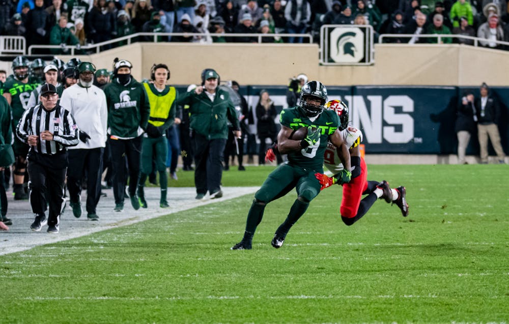 Maryland's Ahmad McCollough (19) tackles Michigan State's Kenneth Walker III (9) during Michigan State's victory on Nov. 13, 2021.