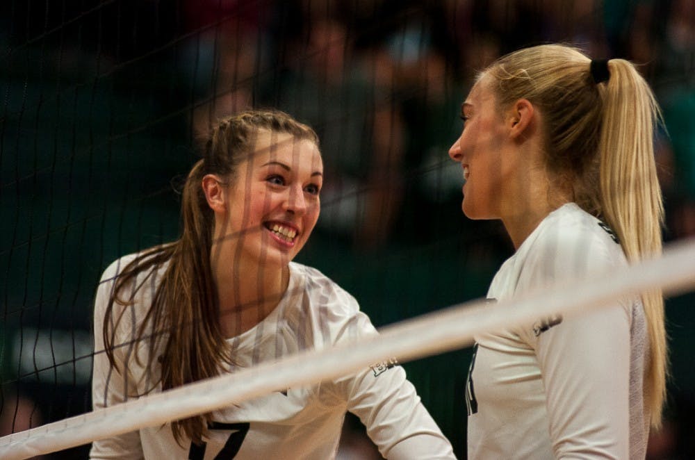 <p>&nbsp;Senior middle blocker Alysaa Garvelink (17) and senior outside hitter Holly Toliver (18) react after a play &nbsp;during the game against Wisconsin on Oct. 7, 2017 at Jenison Fieldhouse. The Spartans defeated the Badgers, 3-1. &nbsp;&nbsp;</p>