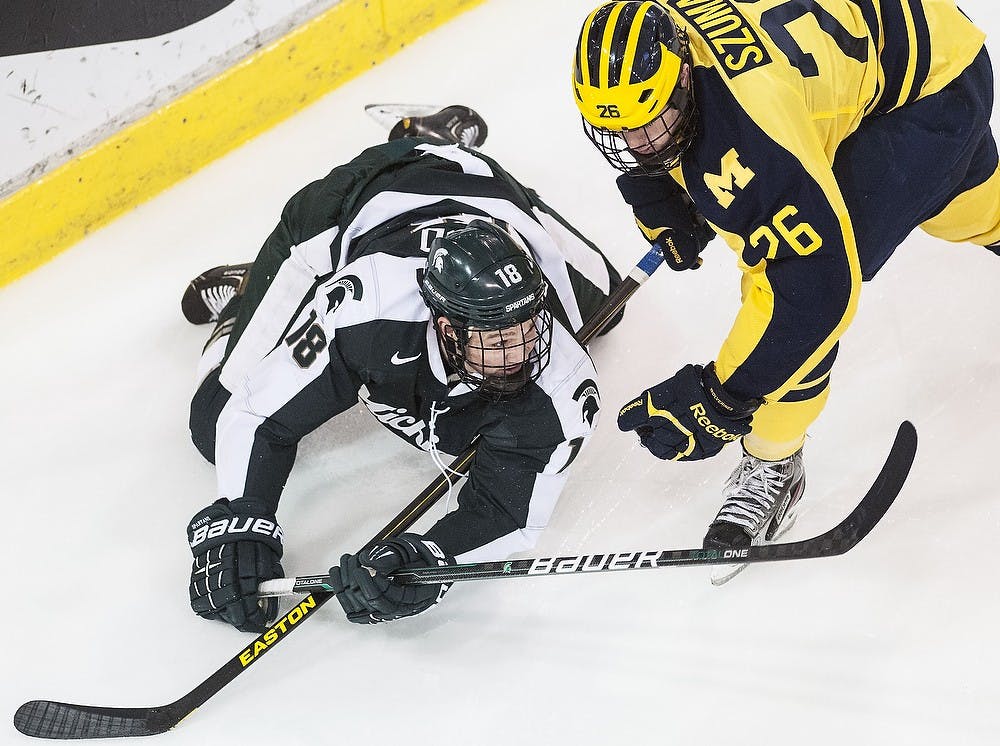 	<p>Senior left wing Kevin Walrod gets taken down to the ice by Michigan defenseman Mike Szuma on Friday, Feb. 1, 2013, at Yost Ice Arena in Ann Arbor. The Wolverines defeated the Spartans, 3-2, in the first game of the weekend series. Adam Toolin/The State News </p>