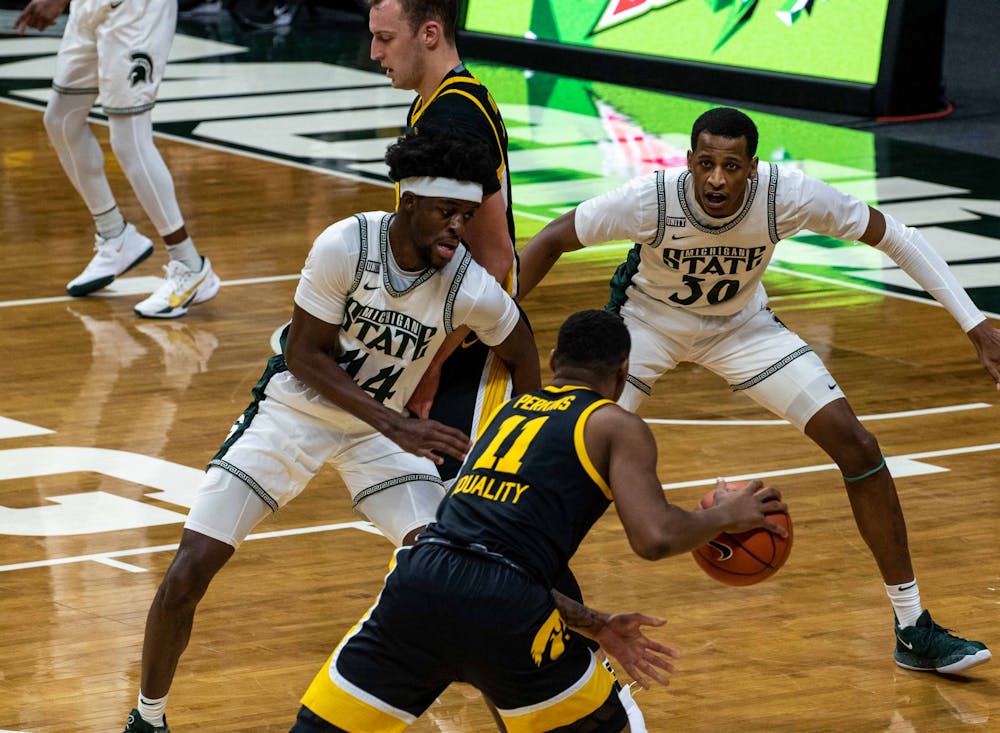 <p>Then-juniors Gabe Brown and Marcus Bingham Jr. try and regain possession of the ball from Iowa&#x27;s Tony Perkins during the second half. The Spartans were crushed by the Hawkeyes, 88-58, on Feb. 13, 2021.</p>