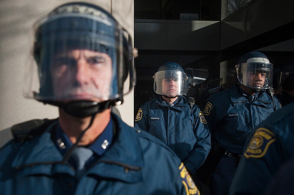	<p>Police officiers guard the George W. Romney Building, 111 S. Capitol Ave. in Lansing, Tuesday, Dec. 11, 2012. About a dozen protestors participated in a civil disobedience sit-in in the public area of the building. Justin Wan/The State News</p>