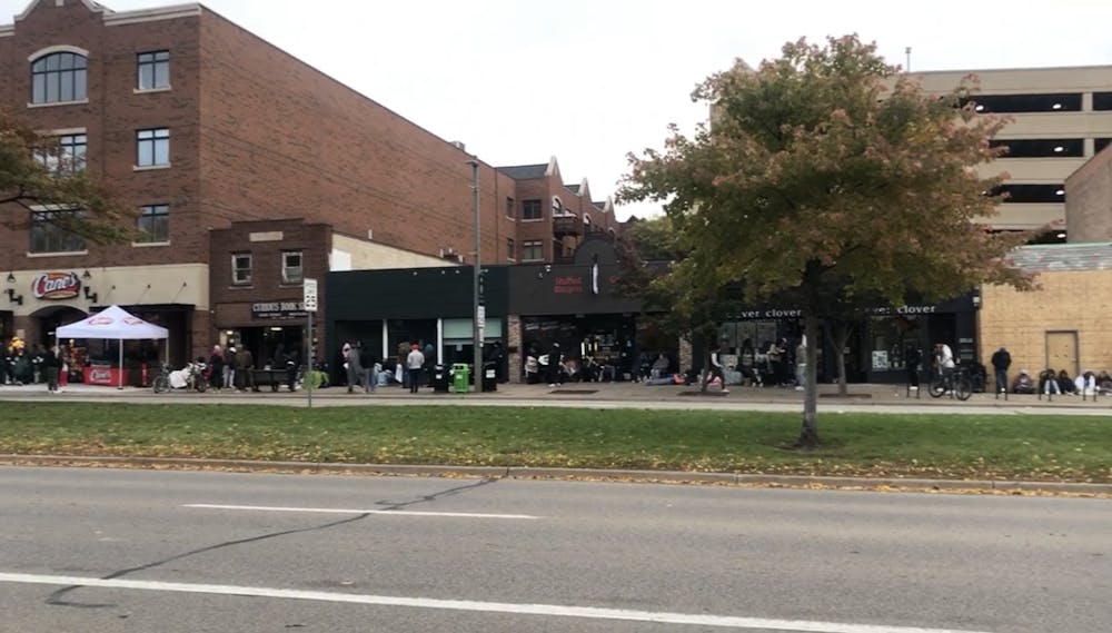 Customers of East Lansing Raising Cane's line up down the street on opening day Oct. 18, 2022.