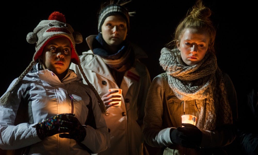 From left to right, English junior Kelsey Wiley, interdisciplinary studies in social science senior Kaitlin Powers and economics junior Ruth Archer attend a vigil to honor the victims of the Planned Parenthood clinic shooting in Colorado on Nov. 30, 2015 at the Rock on Farm Lane. Wiley is the vice president of the MSU Students for Choice. Powers is the secretary of the organization.