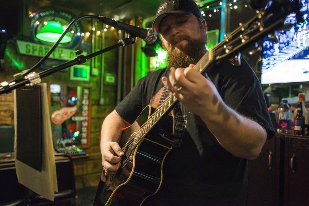 Portland, Mich. resident Russ Holcomb plays a song on the guitar on Feb. 1, 2017 at Crunchy's at 254 E. Grand River Ave. Crunchy's has various musicians play live music every Wednesday from 10 p.m. to midnight.