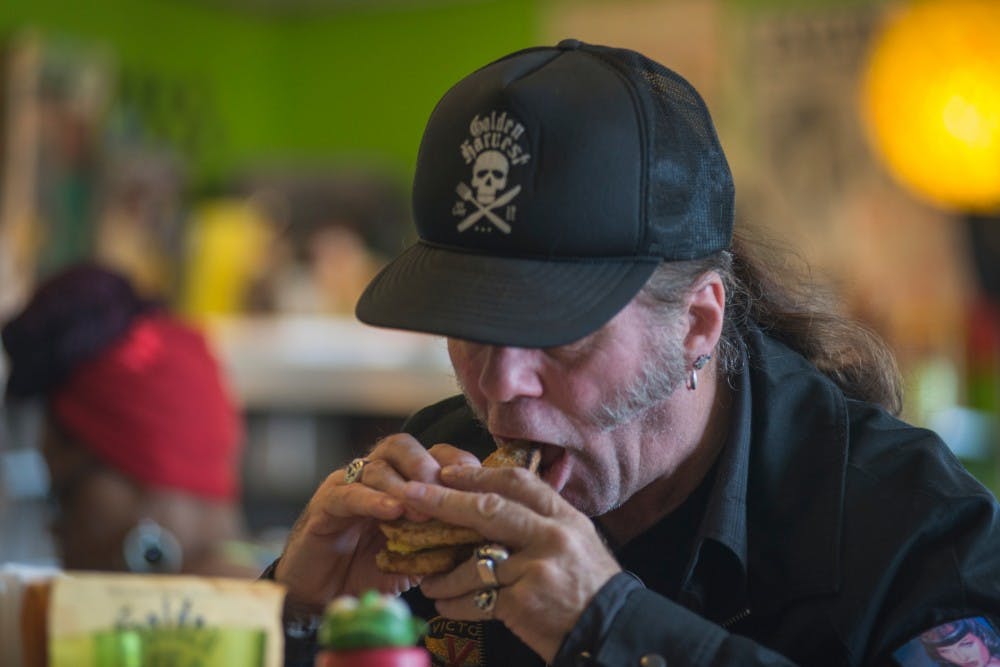 A man who goes by the nickname "Wolf" eats a sandwich on June 8, 2016 at Golden Harvest at 1625 Turner St. in Lansing, Mich.