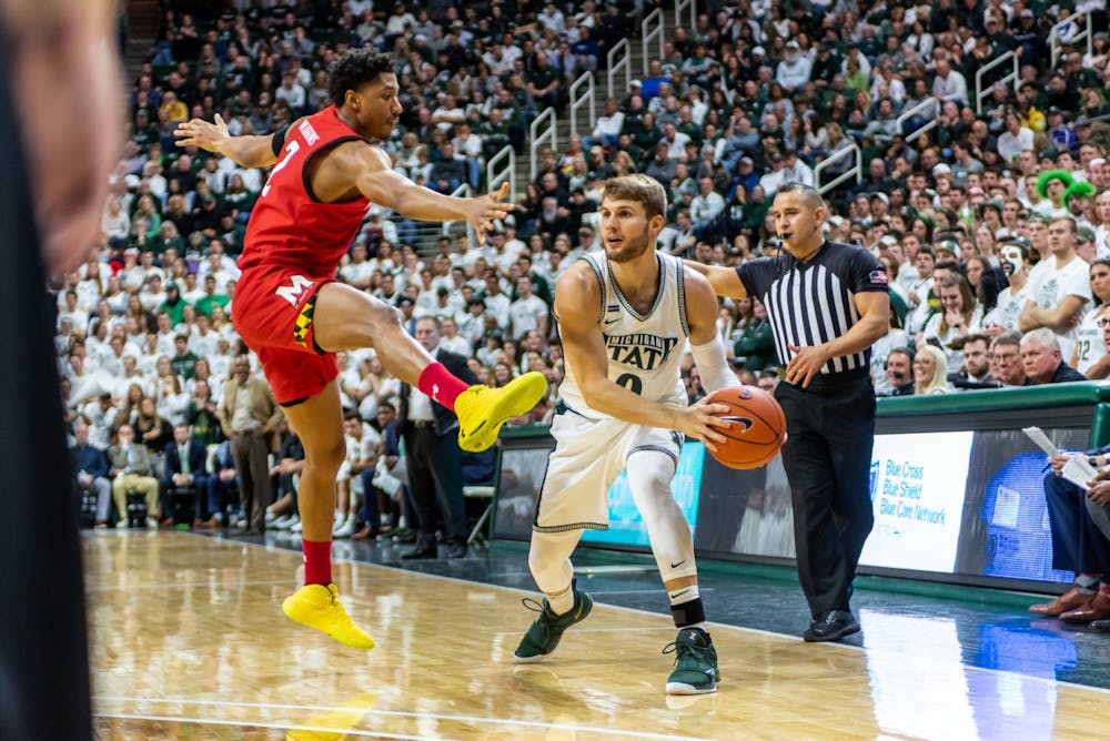 <p>Senior forward Kyle Ahrens (right) looks to pass the ball against Maryland’s Aaron Wiggins (left).The Spartans fell to the Terrapins, 60-67, at the Breslin Student Events Center on Feb. 15, 2020. </p>