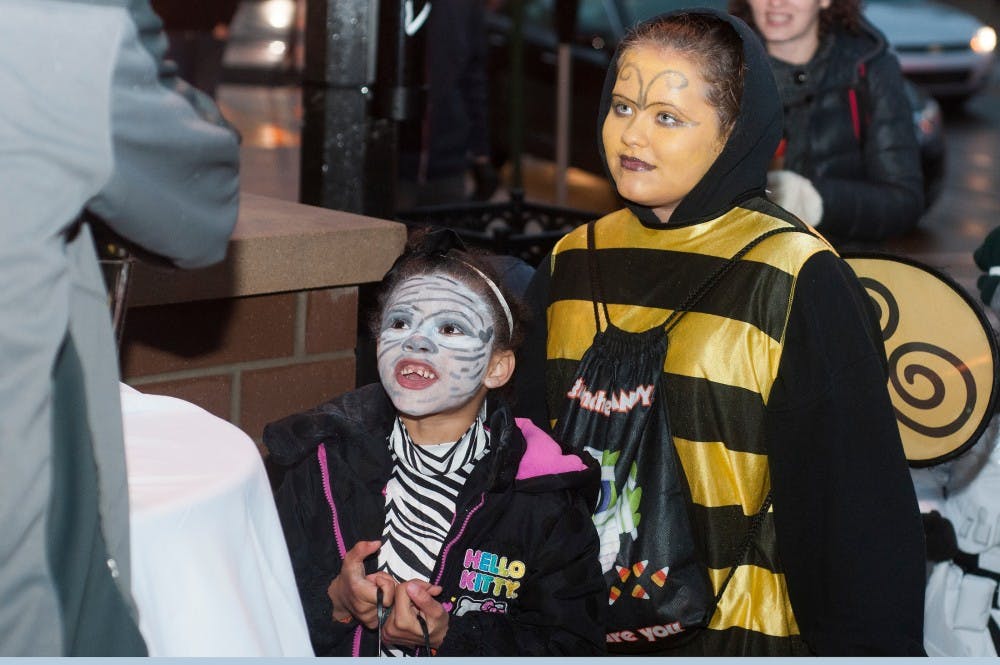<p>From left to right, Lansing residents Nevaeh Evans, 6, and Roemen Evans, 10, trick-or-treat on Oct. 29, 2015 on MAC Avenue. Navaho and Roemen are participating in Safe Halloween, which is run by the City of East Lansing and allows children to trick-or-treat in a safe environment. </p>