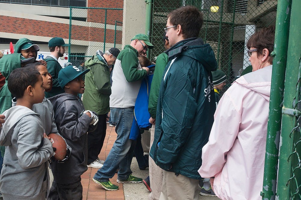 <p>Spartan fans enter the gates prior to the Green and White Spring game April 25, 2015, at Spartan Stadium. The white team defeated the green team, 9-3. Hannah Levy/The State News</p>