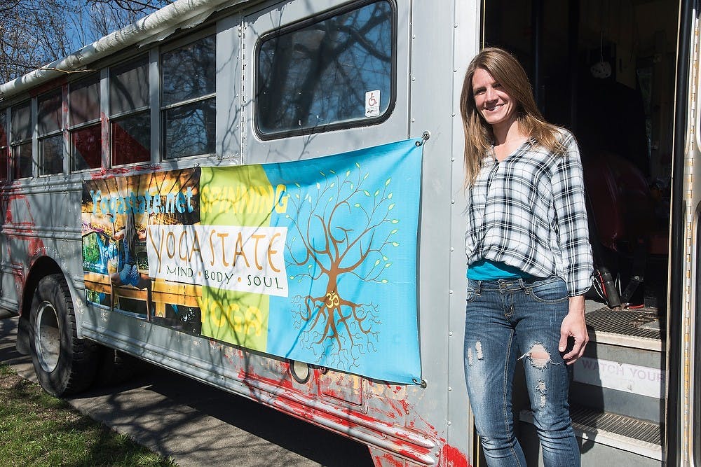 <p>Owner of Yoga State Jen Hayes poses at the door of her Yoga Bus April 28, 2015, at her home on e. Lake Lansing Rd. in East Lansing. Hayes drives the bus all around East Lansing promoting her business by giving people rides and passing around flyers. Erin Hampton</p>