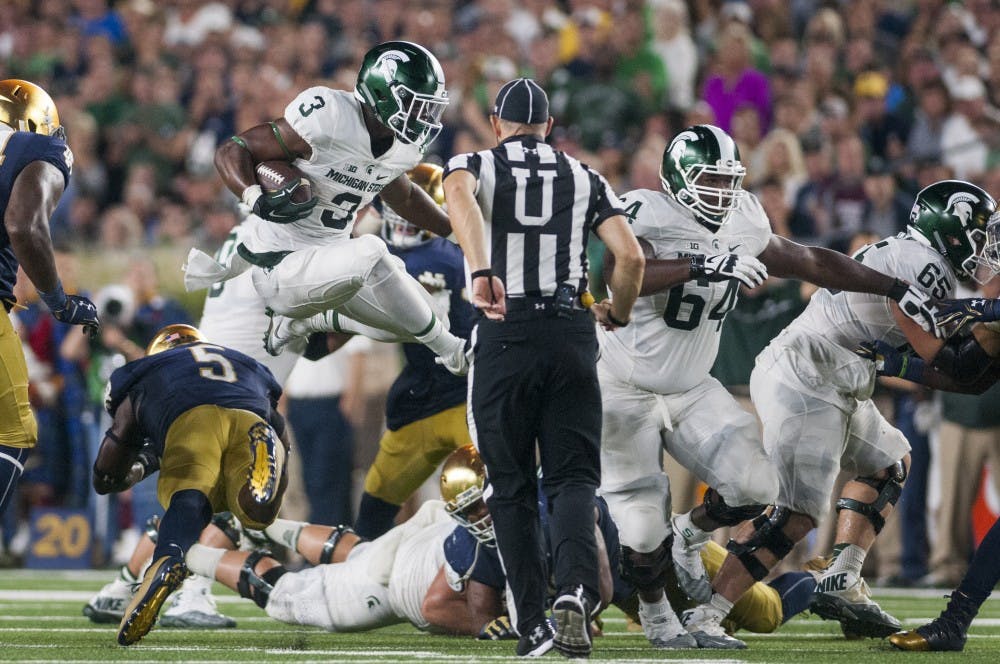 Sophomore running back LJ Scott (3) leaps over Notre Dame linebacker Nyles Morgan (5) during the game against Notre Dame on Sept. 17, 2016 at Notre Dame Stadium in South Bend, Ind. 