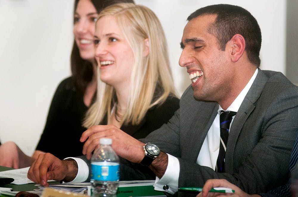 From left, Council of Graduate Students (COGS) Medical Schools Liaison Jane Christman, COGS Parliamentarian Shannon Demlow, and COGS President Stefan Fletcher laugh as Fletcher is re-elected during a COGS monthly meeting on Wednesday, March 13, 2013, in room 111 of Olds hall. Fletcher ran as the sole candidate for president. Danyelle Morrow/The State News