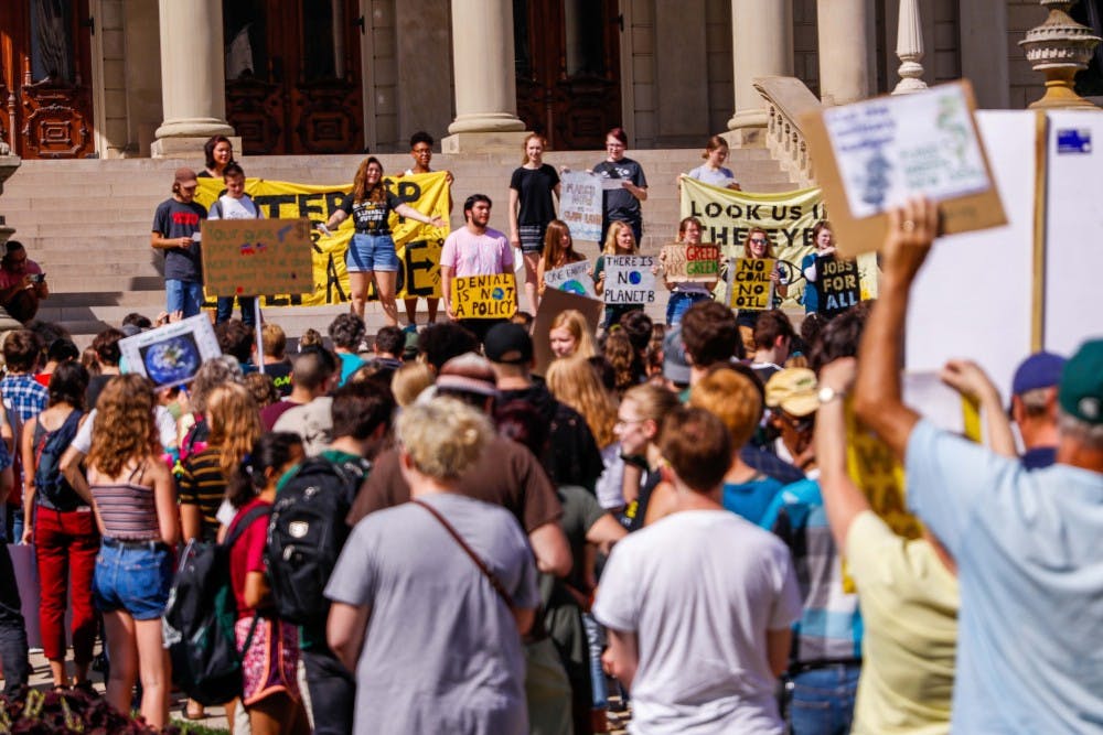 The crowd at the Global Climate Strike sings a song at the Capitol building in Lansing Sep. 20, 2019.