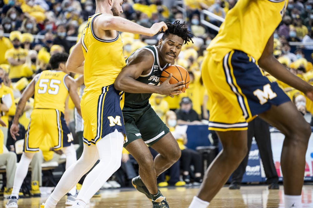 <p>Junior forward Julius Marble pushes through players at the game against Michigan at the Crisler Center on March 1, 2022.</p>