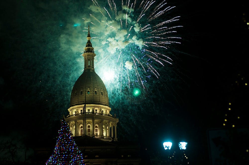 	<p>Fireworks explode over the Capitol Building after the lighting of the tree during Silver Bells on Nov. 23, 2013, in downtown Lansing. Community members gathered from across the greater Lansing area to view the lighting of the tree. Danyelle Morrow/The State News</p>