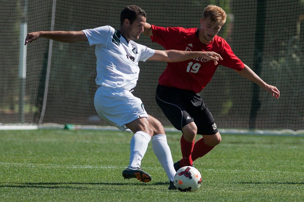 	<p>Junior forward Adam Montague and Northern Illinois defender Dusty Page battle for possession of the ball on Sept. 28, 2013, at DeMartin Stadium at Old College Field. The Spartans defeated the Huskies, 2-0. Julia Nagy/The State News</p>