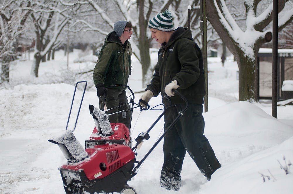 	<p>Finance sophomore Jesse Jezak, right, and supply chain management sophomore Ben Fudala remove snow Jan. 5, 2014, in front of a Spartan Village laundry facility. The student employees were part the snow removal efforts throughout Spartan Village. Christina Strong/The State News </p>