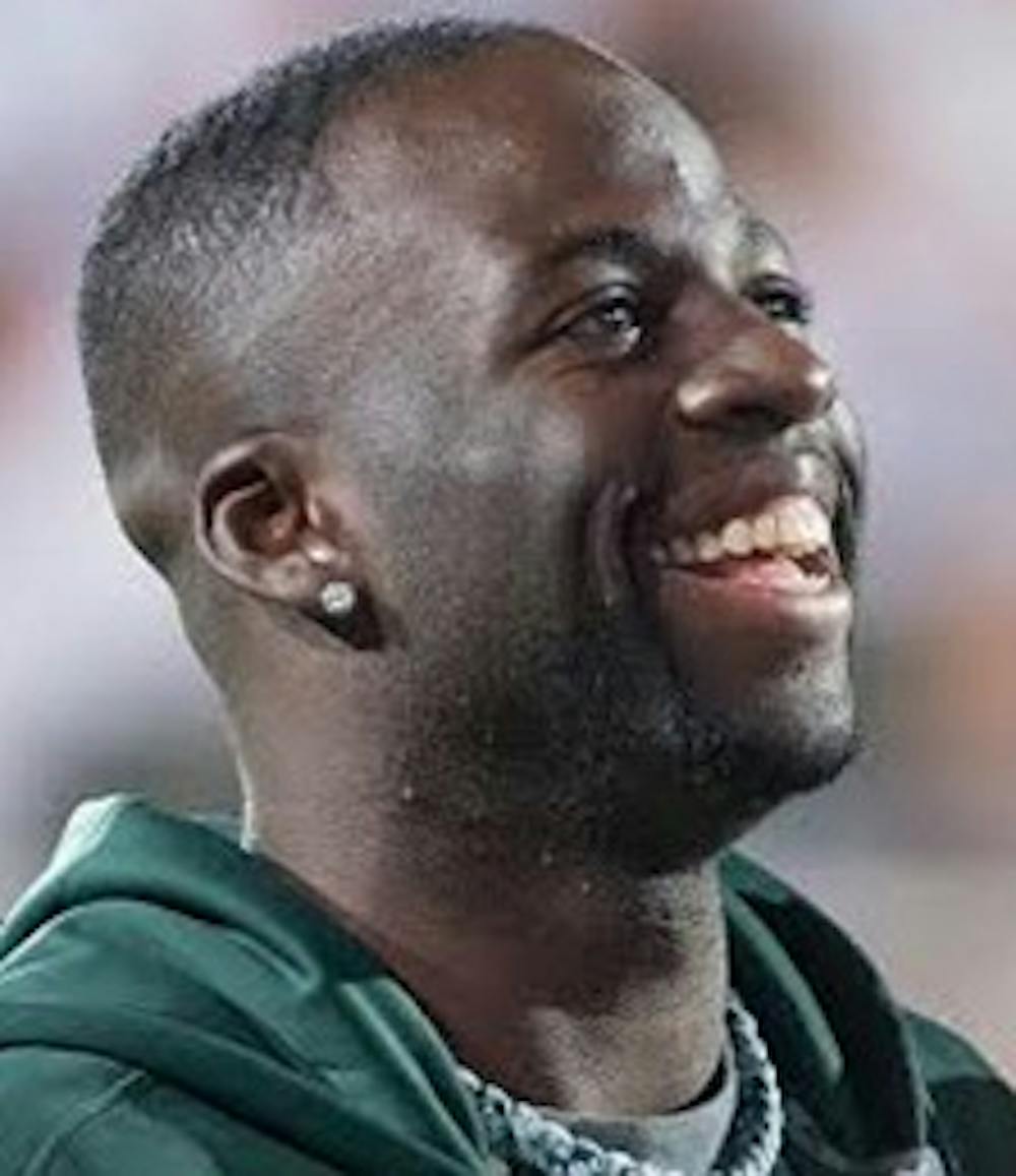 MSU basketball head coach Tom Izzo and former Spartan and current Golden State Warrior forward Draymond Green look out at the crowd during the game against Oregon on Sept. 12, 2015 at Spartan Stadium. Green was recognized for his recent donation to the Spartan basketball program. Alice Kole/The State News