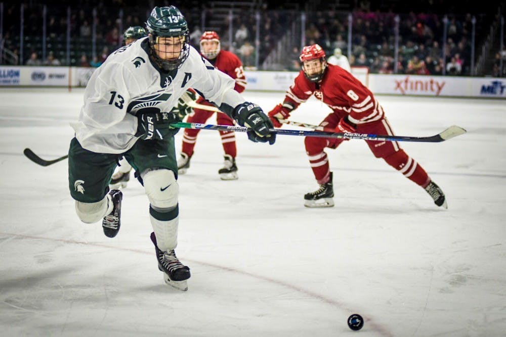 Junior forward Brennan Sanford (13) chases after the puck during the game against Wisconsin on Nov. 11, 2017 at Munn Ice Arena. The Spartans defeated the Badgers, 2-0. 