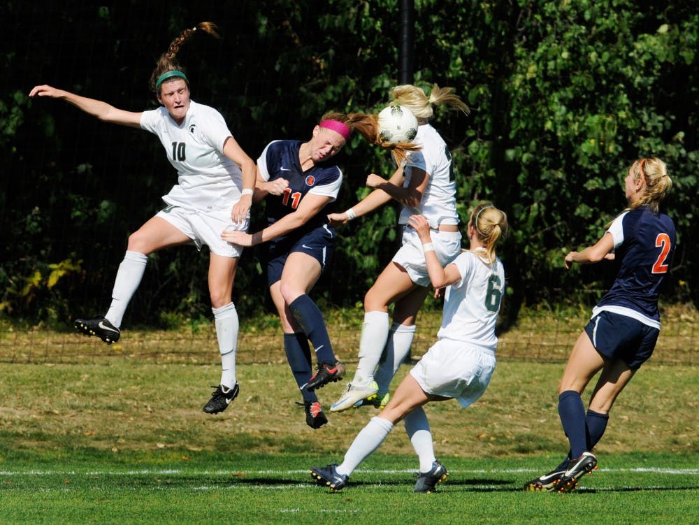 Illinois redshirt sophomore Jannelle Flaws performs a header in front of the Spartan goal as she jumps up along with other MSU players. The Fighting Illini defeated the Spartans Saturday afternoon by 1-0 during the second overtime at DeMartin Stadium at Old College Field. Justin Wan/The State News